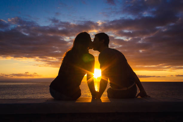 Couple silhouette enjoying romantic colorful twilight. Valentines Day, honeymoon romantic date concepts