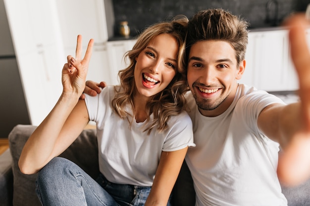 joyful-young-man-making-selfie-with-his-beautiful-girlfriend-home-couple-with-smile-joy-their-eyes_197531-12145